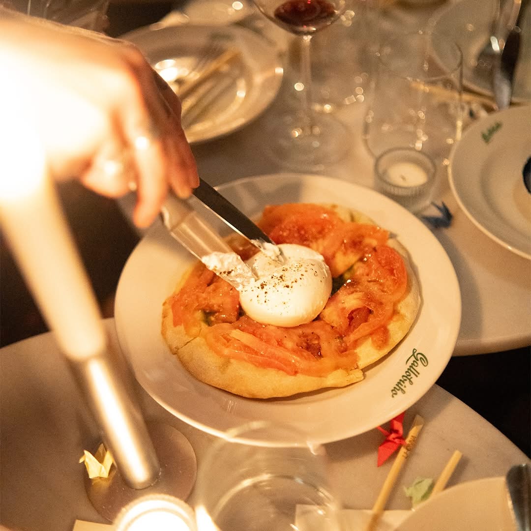 Burrata con tomate servida a la luz de las velas en una mesa de Gallobúho